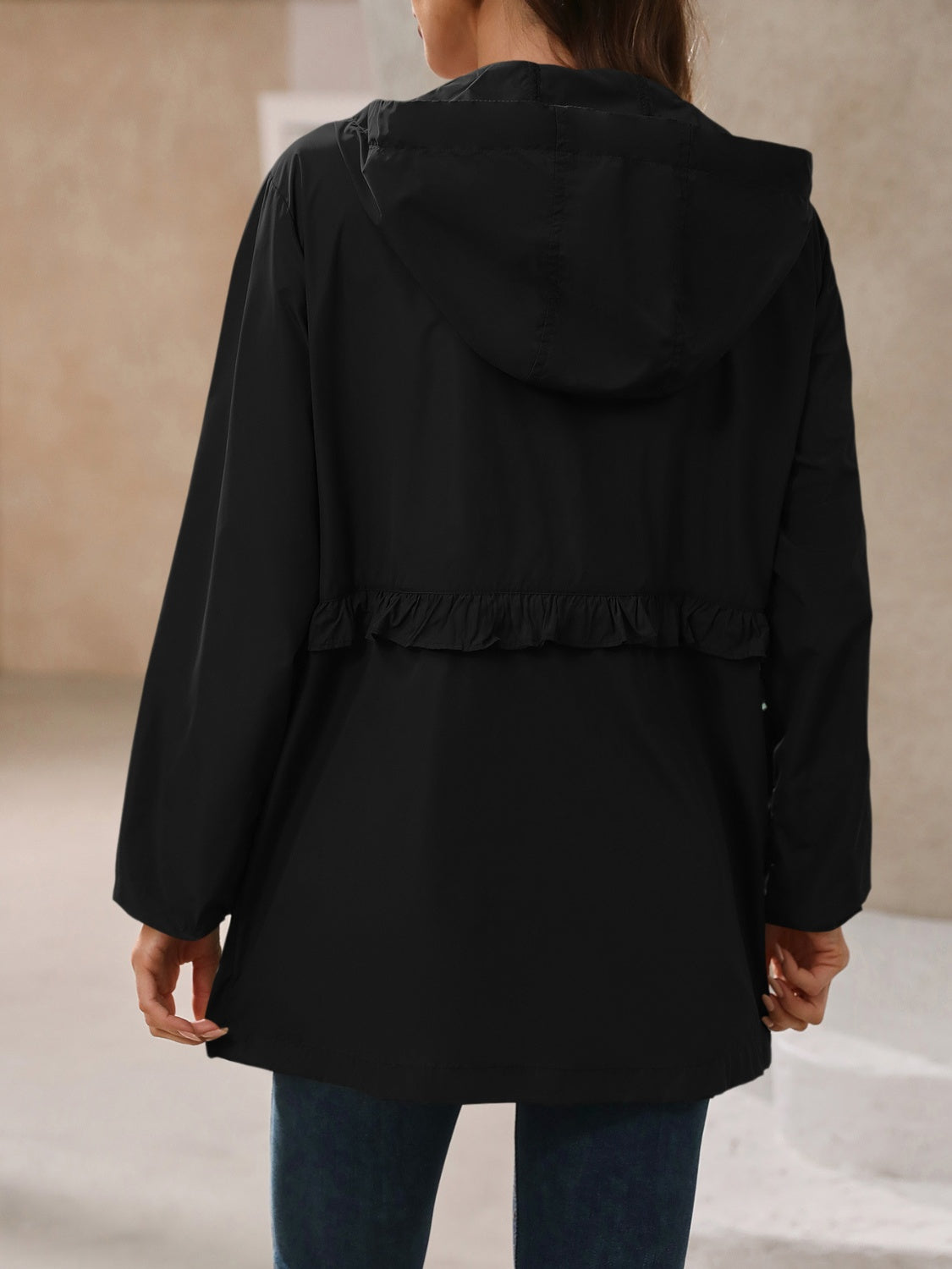 Black hooded waterproof windbreaker jacket, back view with cinched waist