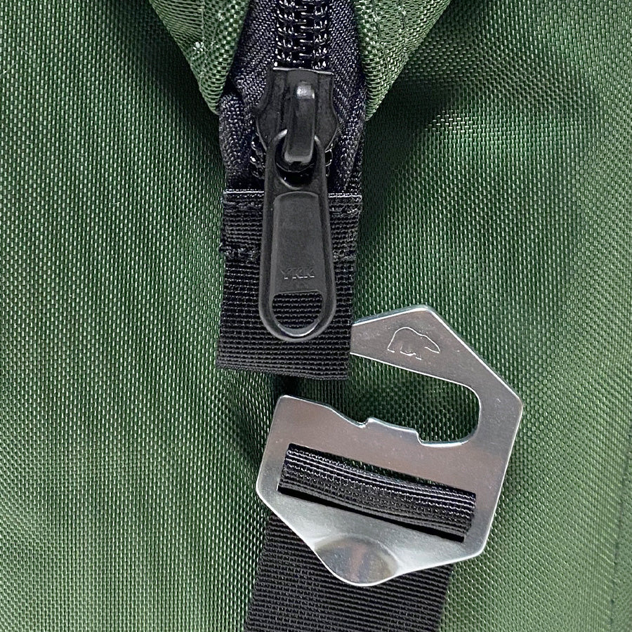 Close-up of metal clasp and zipper pull on green fabric cooler strap