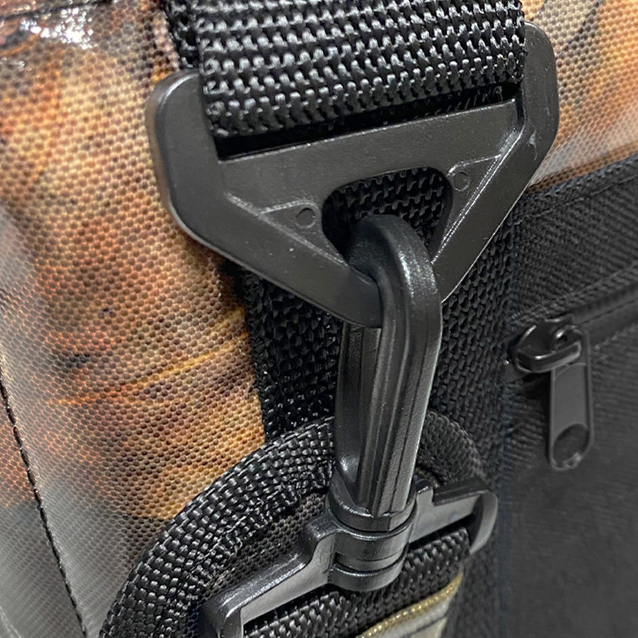 Camouflage cooler bag close-up of strap latch, zipper teeth, and metal clip