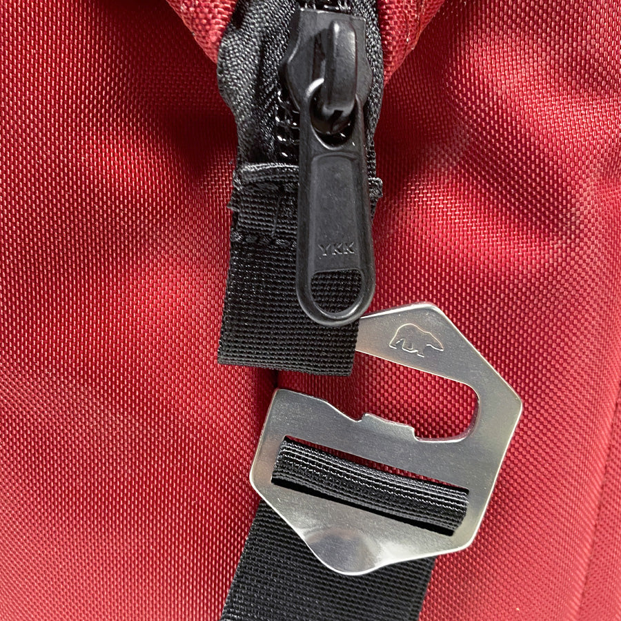 Close-up of red cooler front strap hardware with metal D-ring and YKK zipper