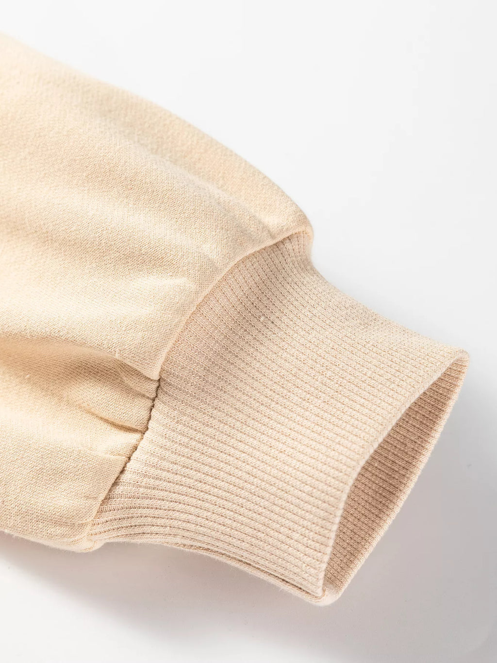 Beige sweatshirt sleeve cuff with gathered seam at drop shoulder