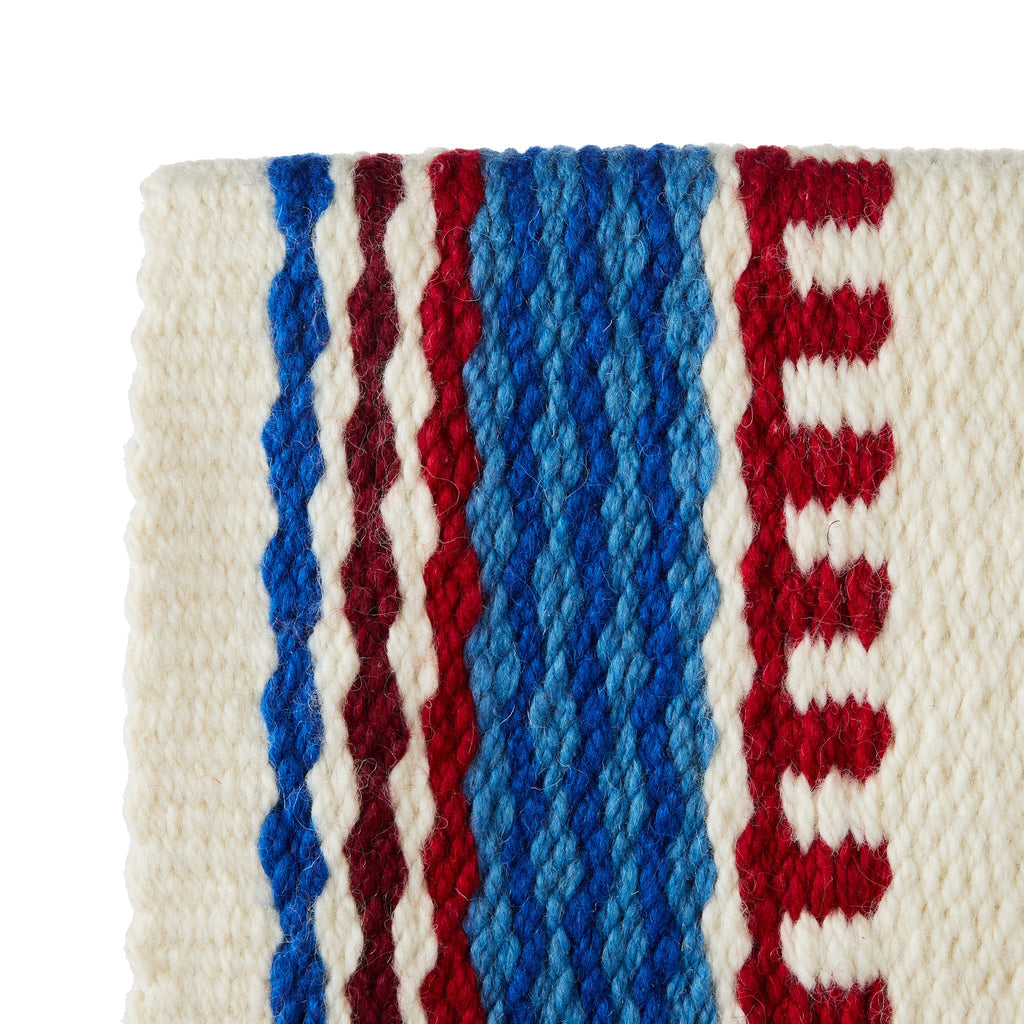 Wool saddle blanket close-up showing cream weave with blue center stripe and red borders