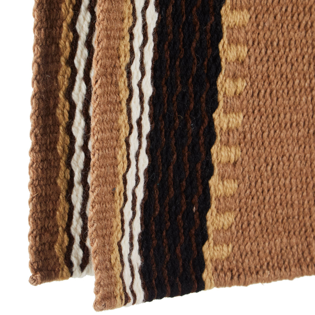 Close-up of brown, tan, and black woven saddle blanket with vertical striped bands