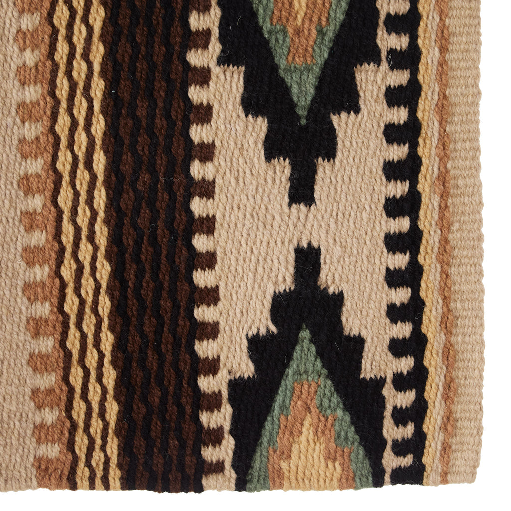 Wool saddle blanket close-up with black star and zigzag trim on cream striped fabric
