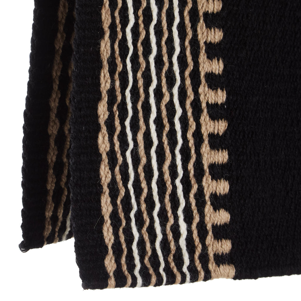 Wool saddle blanket close-up with alternating black and tan vertical stripe trim