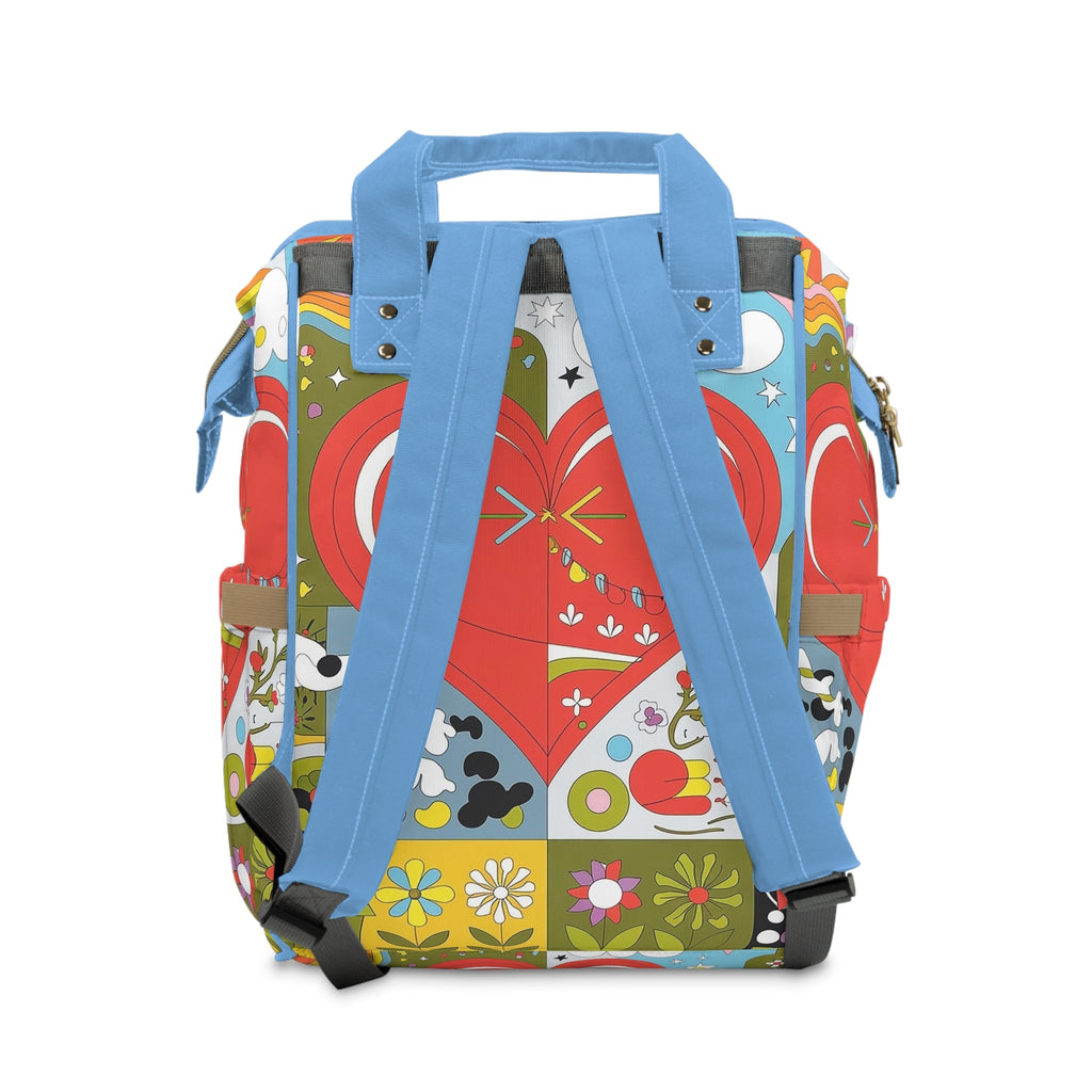 Diaper backpack with blue back straps and colorful heart-pattern quilt front panel