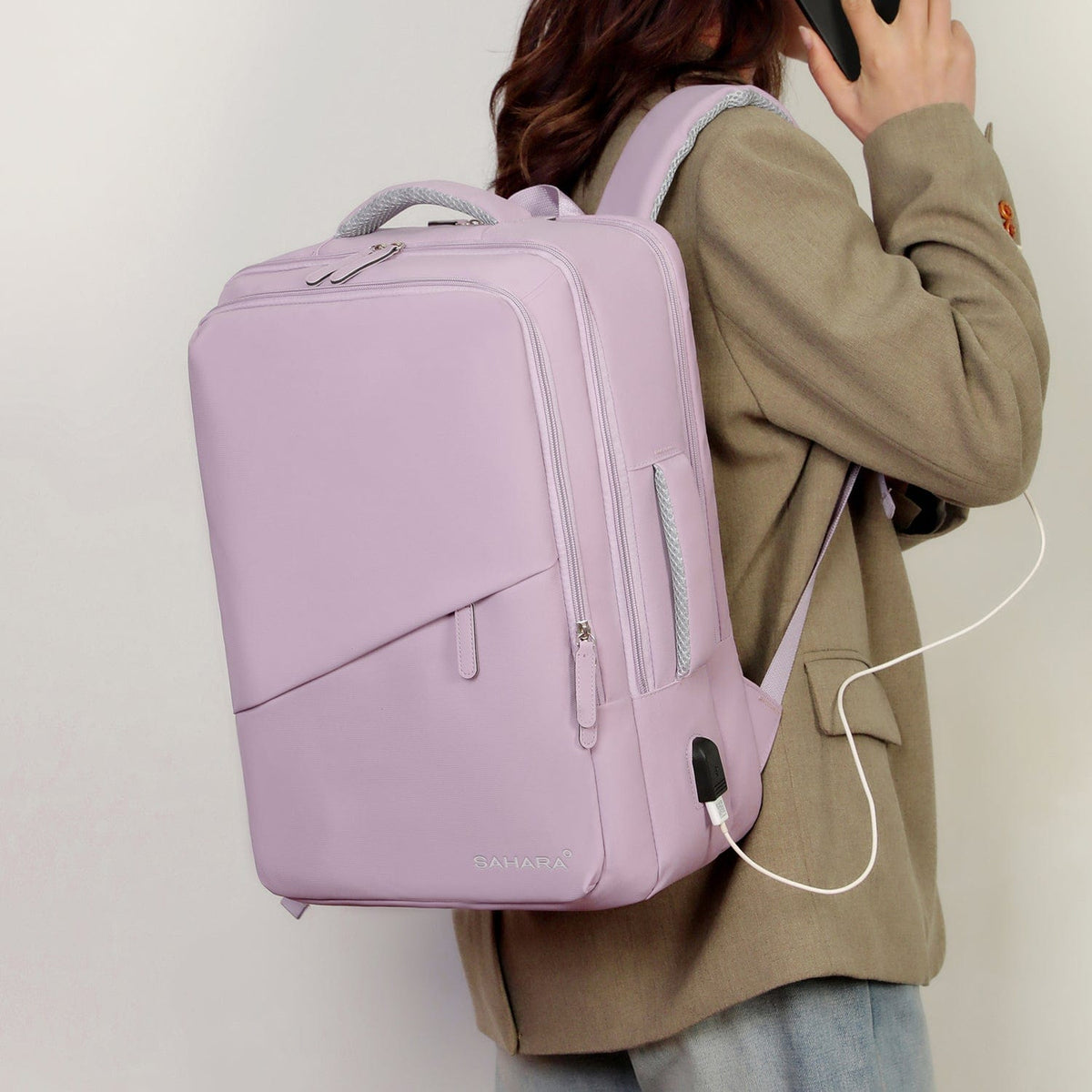 Purple travel backpack worn with front zipper and mesh pocket details