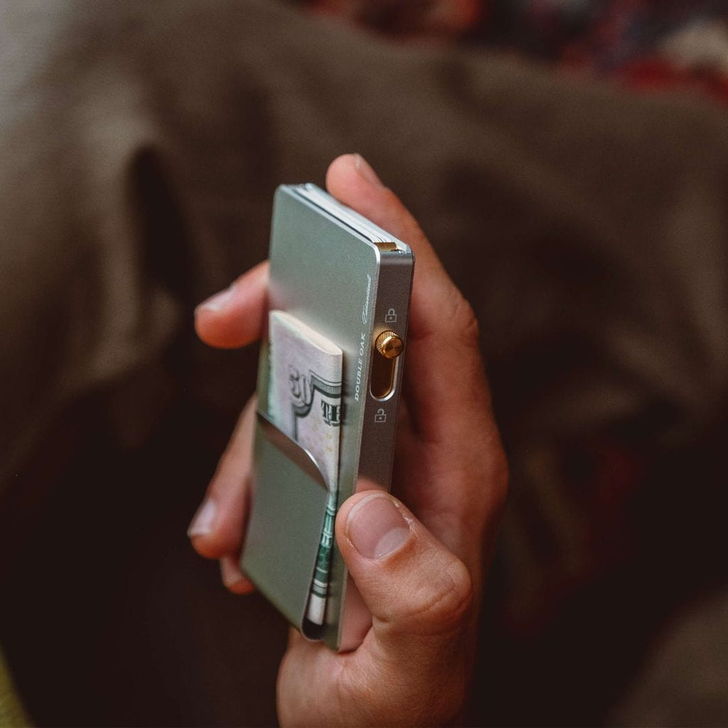 Light blue pop-up cardholder with gold latch, held in hand close-up