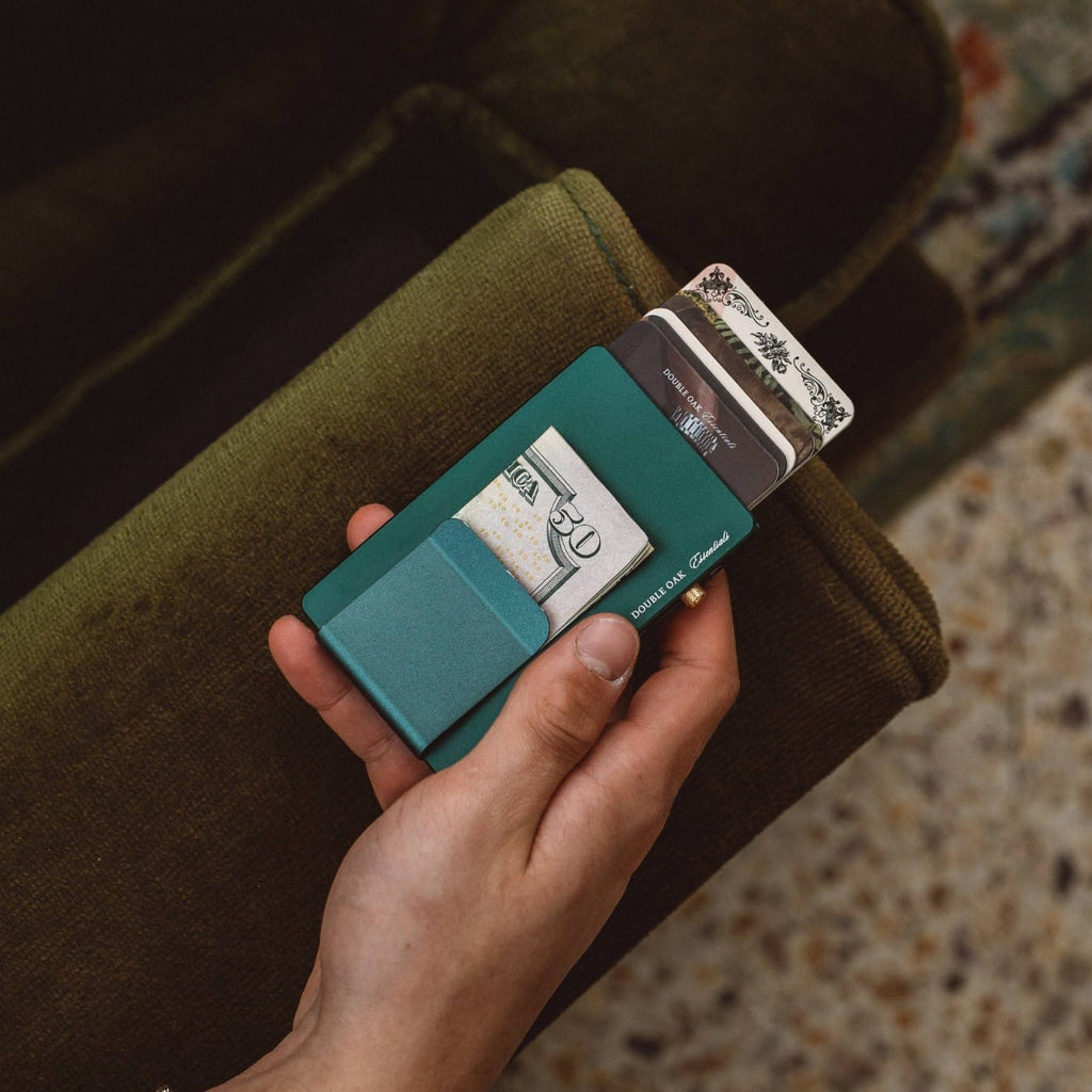 Teal pop-up cardholder with card extended from the center slot in hand