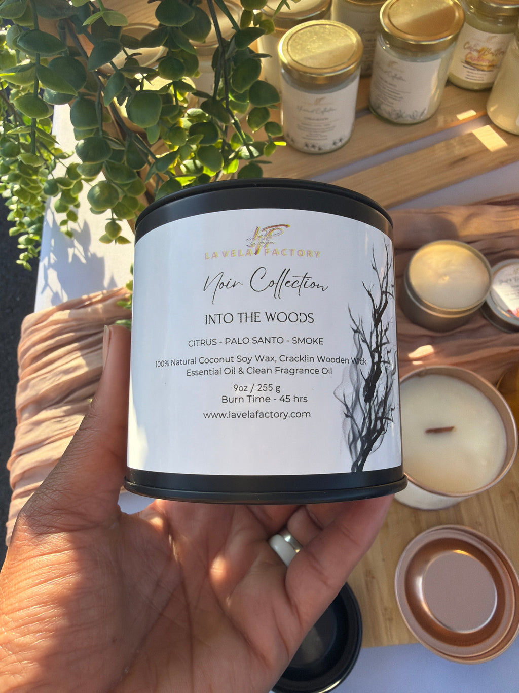 Amber glass jar candle with black lid, label for “Into the Woods”