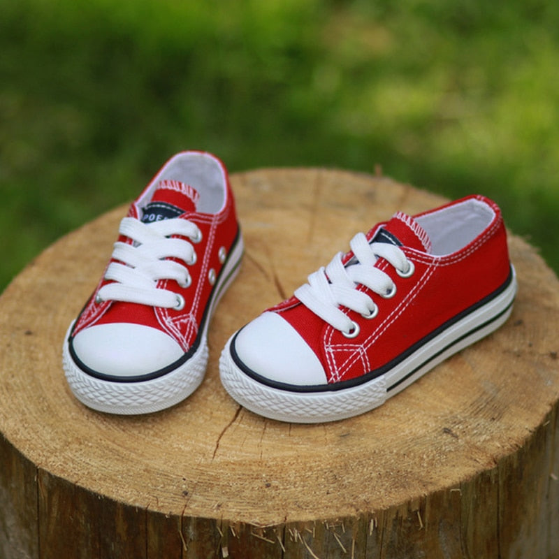 Red low-top canvas sneakers with white laces and grippy rubber sole