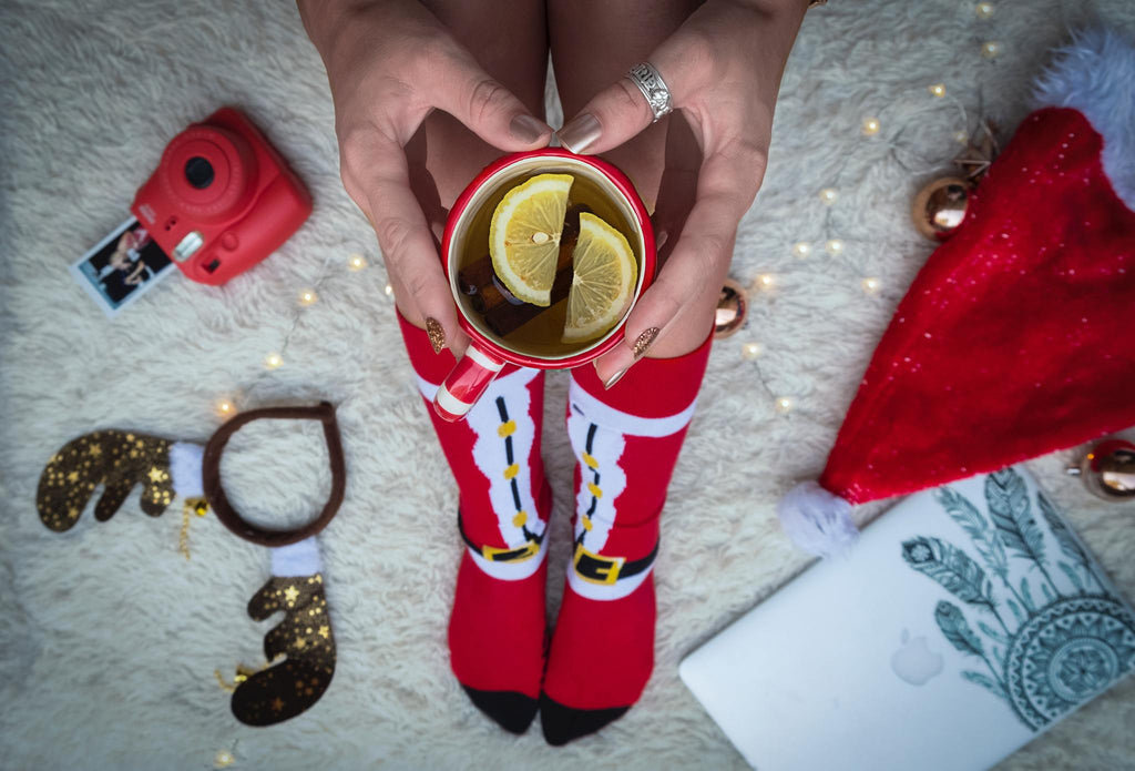 Pair of red Santa-themed socks with decorative graphics and white trim cuffs