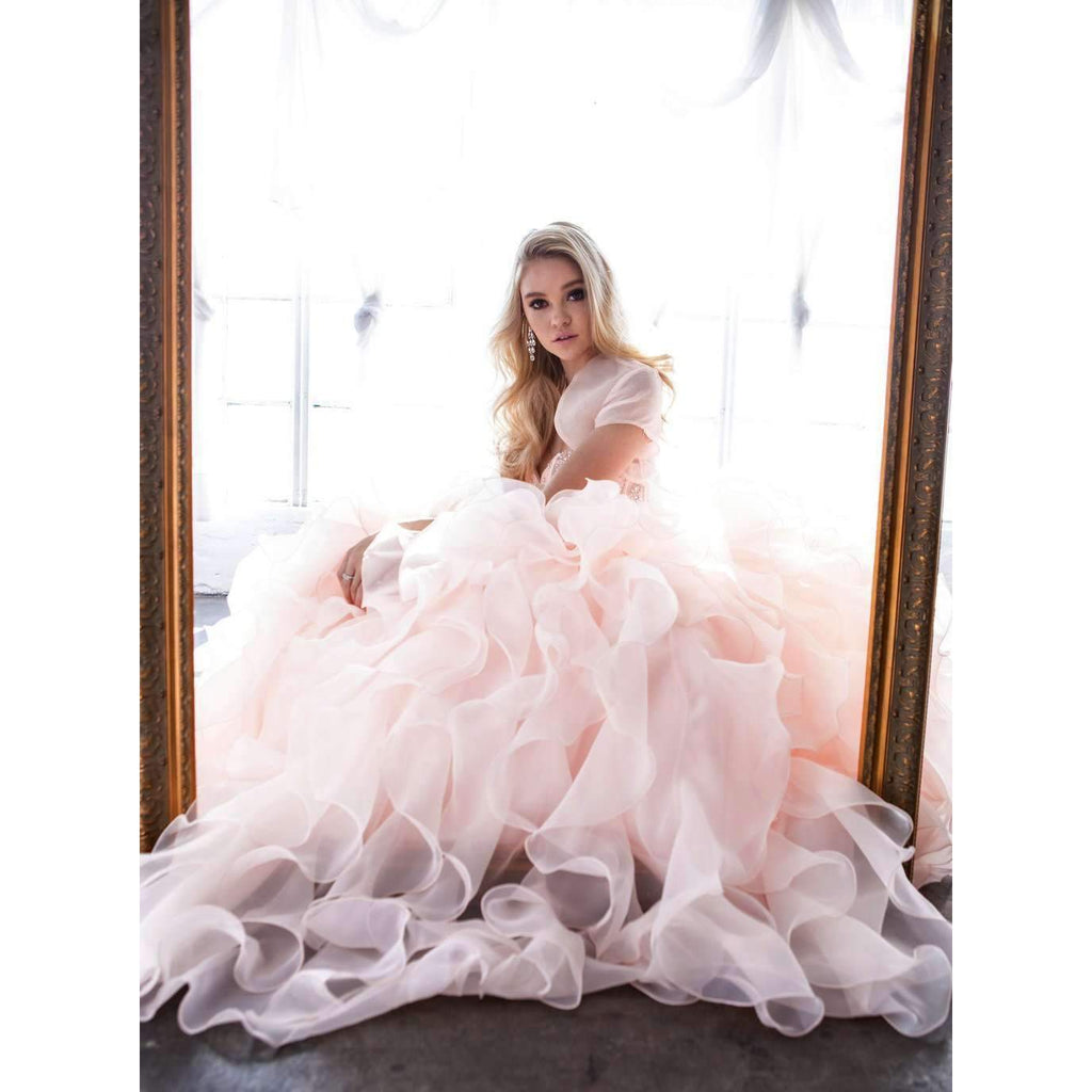 Pink ball gown with beaded bodice and full organza ruffle skirt, seated pose