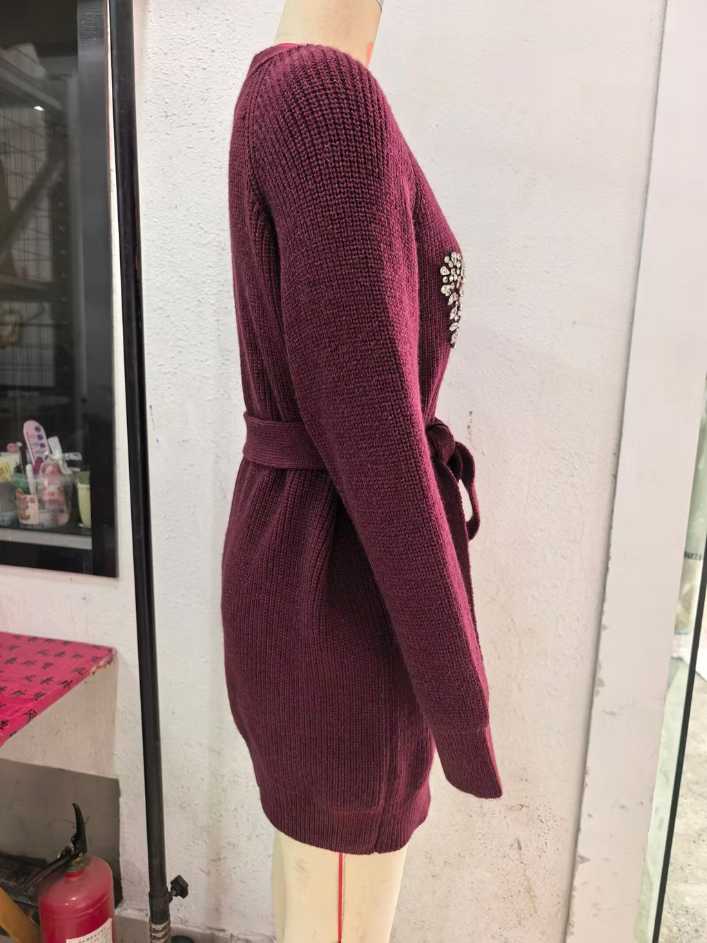 Burgundy knitted cardigan side view with long sleeves and waist tie belt