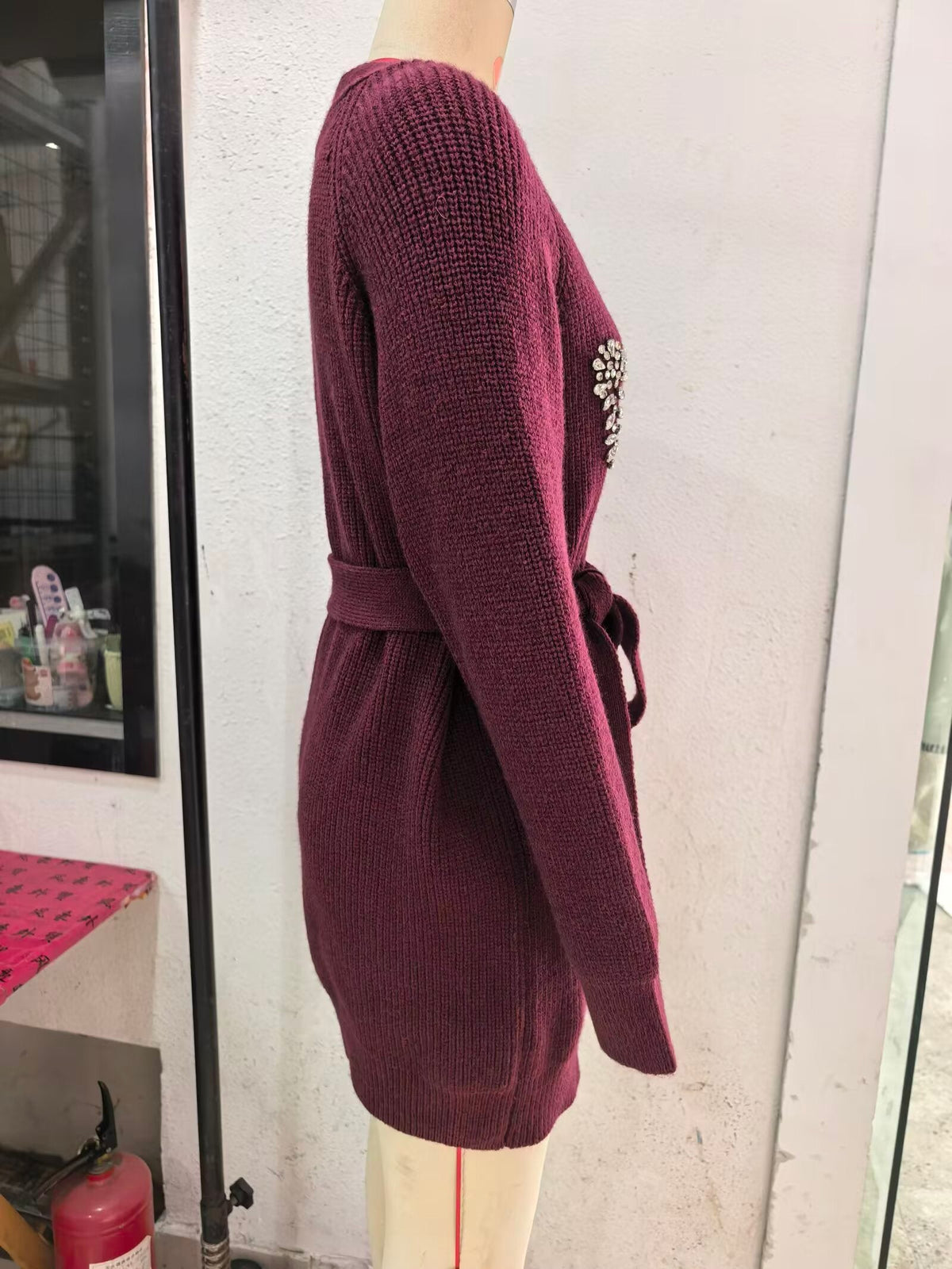 Burgundy knitted cardigan side view with long sleeves and waist tie belt