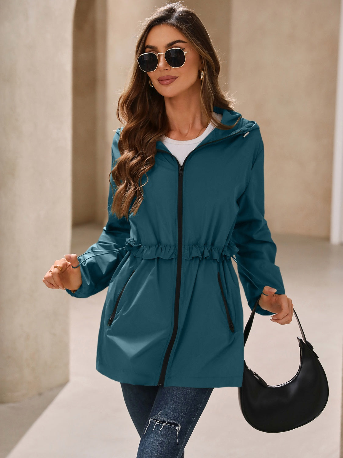 Teal hooded windbreaker jacket with zip front and ruffled waist detail
