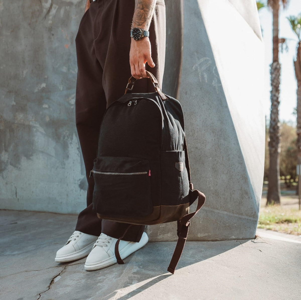Black canvas backpack with large front pocket and adjustable strap