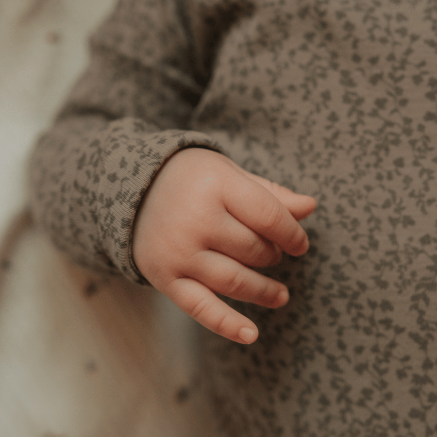 Baby jacket sleeve close-up with speckled fabric and ribbed cuff