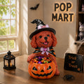 Brown dog witch figurine holding a pumpkin candy bowl, wearing a black hat and cape