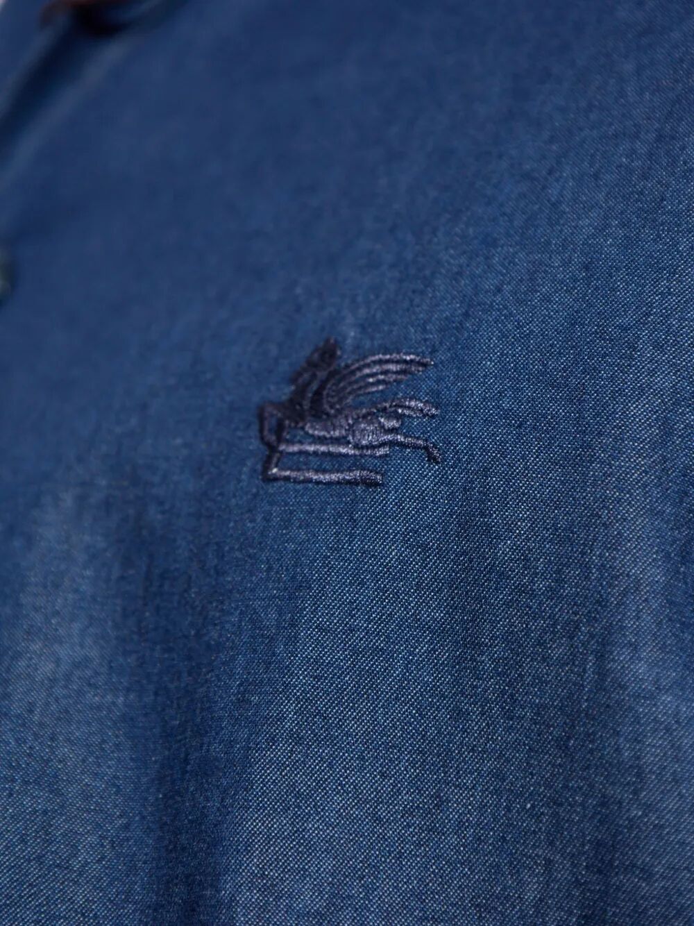 Embroidered logo detail on blue cotton shirt chest