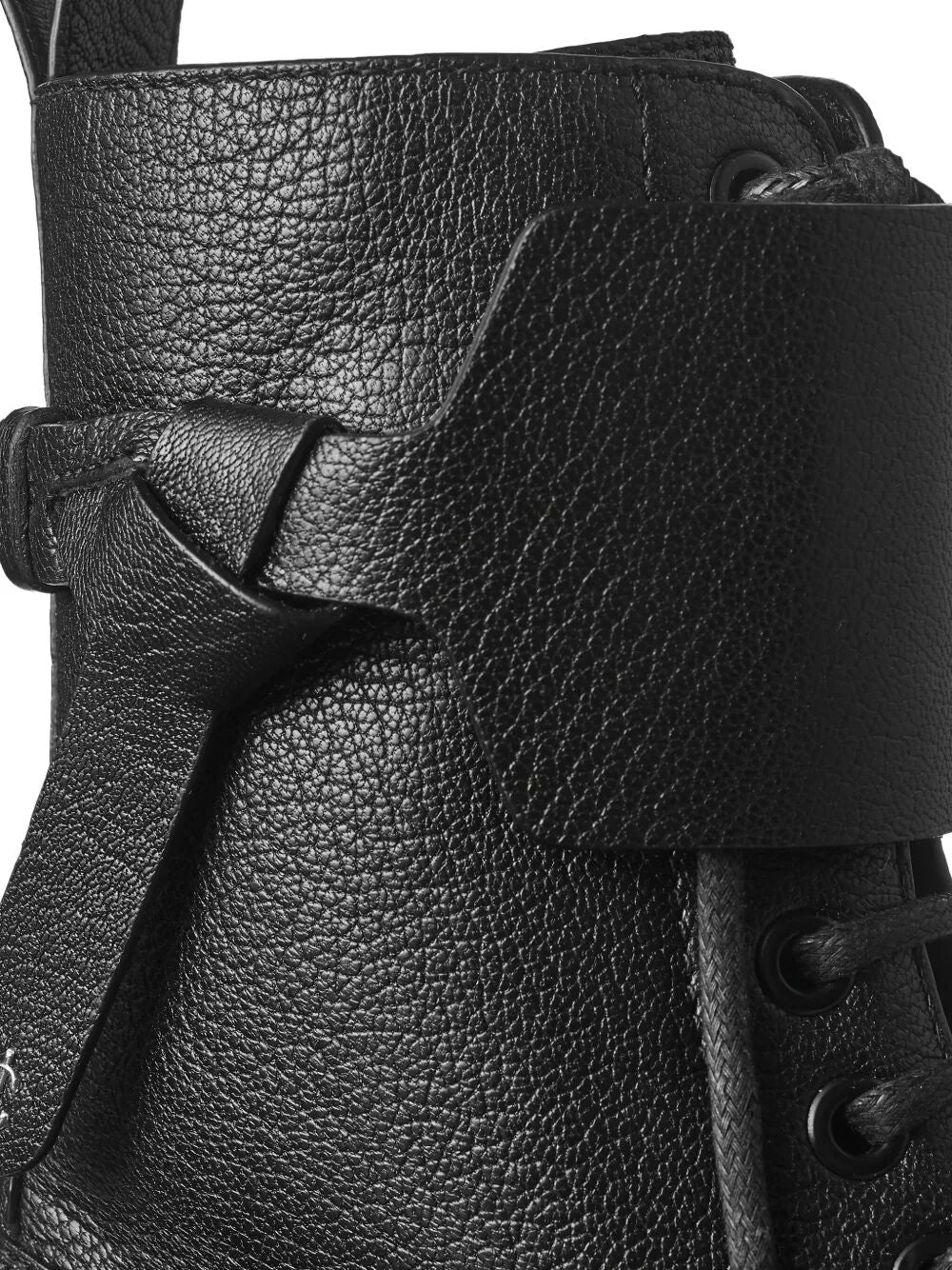 Black leather combat boot close-up with side strap and lace eyelets