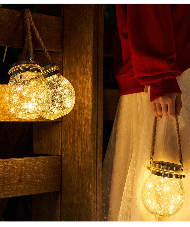 Crackle glass jar light with gold cap and rope handle, warm glow