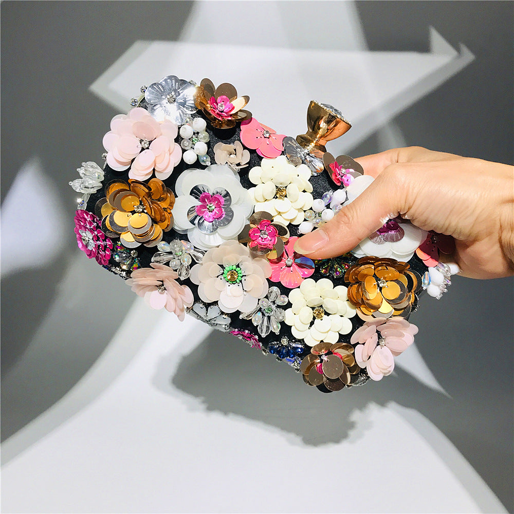 Floral sequin clutch bag with gold-tone chain strap and layered flower embellishments