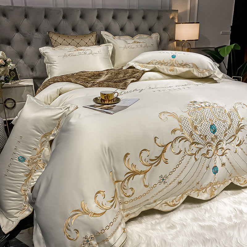White quilted bed sheet set with gold and blue ornate embroidery and matching pillowcases