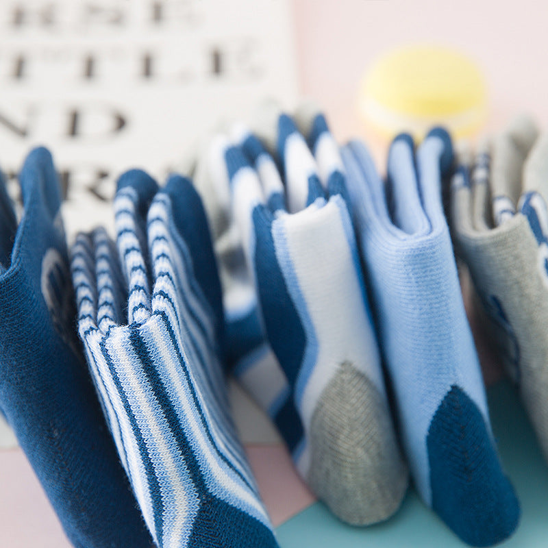 Close-up of baby socks in blue and gray, striped bands and car graphics