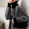 Women’s knit turtleneck sweater in dark charcoal, loose sleeves with ribbed cuffs.