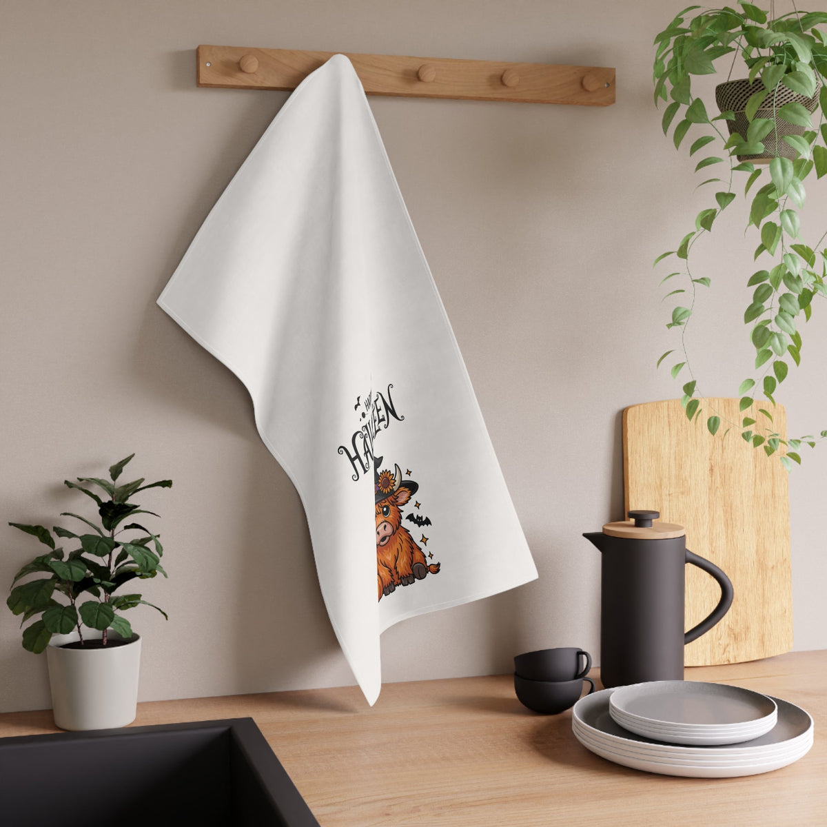 White hanging Halloween tea towel with highland cow illustration and “Happy Halloween” text