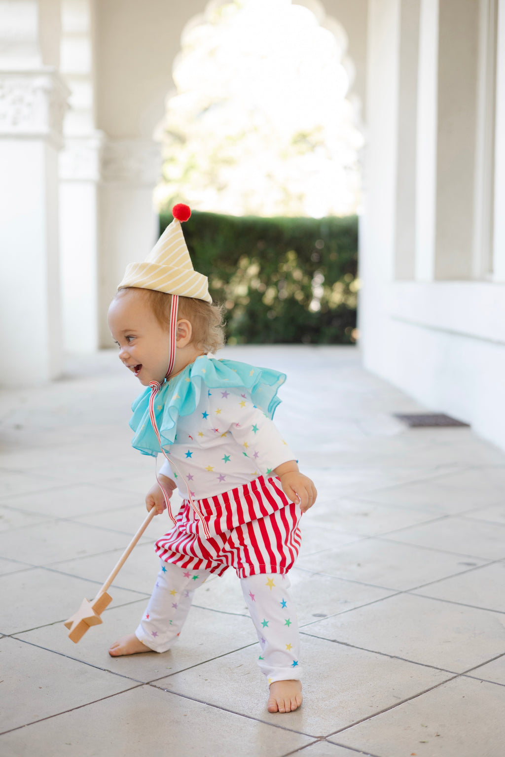 Kids clown costume: yellow striped hat, blue ruffle top, star leggings, red striped shorts