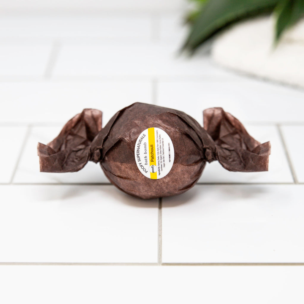 Bath bomb, dark brown round with crinkled ends and round white label