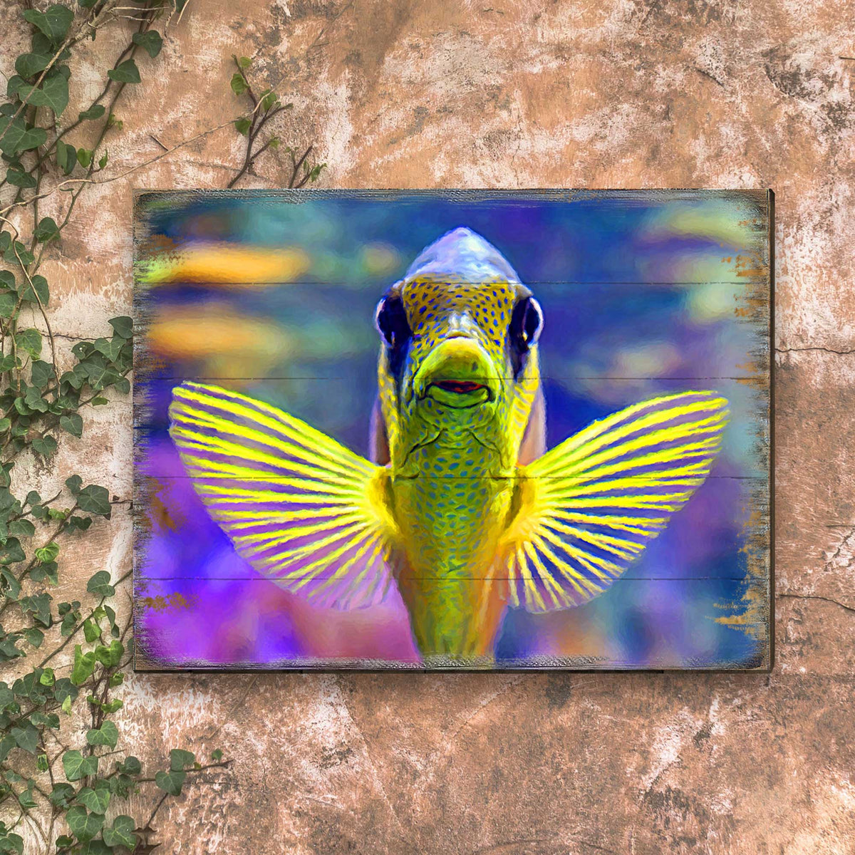 Tropical fish wall art in a distressed frame with winged fish design, vivid colors.