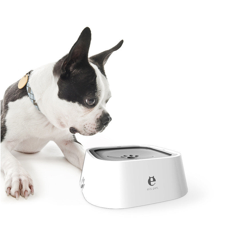 White pet water bowl with paw-print side grips and dark top tray, used by a dog