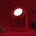 Compact foldable LED lantern light with red body and glowing white circular lens