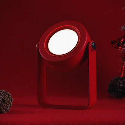 Compact foldable LED lantern light with red body and glowing white circular lens