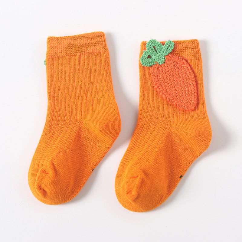 Pair of orange baby socks with green leaf and orange applique detail at the top