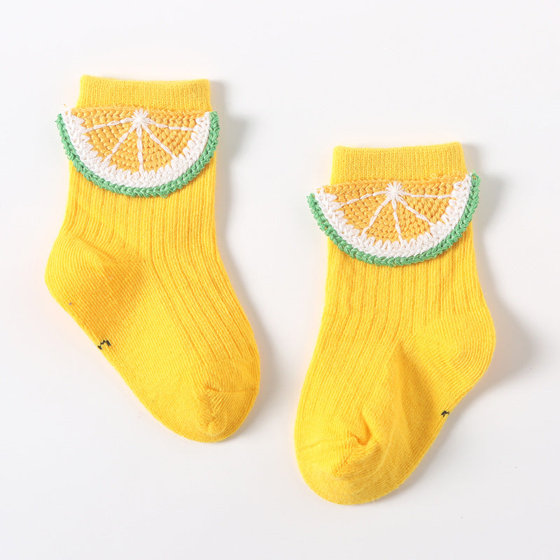 Pair of yellow baby socks with white-and-green citrus slice applique on the instep