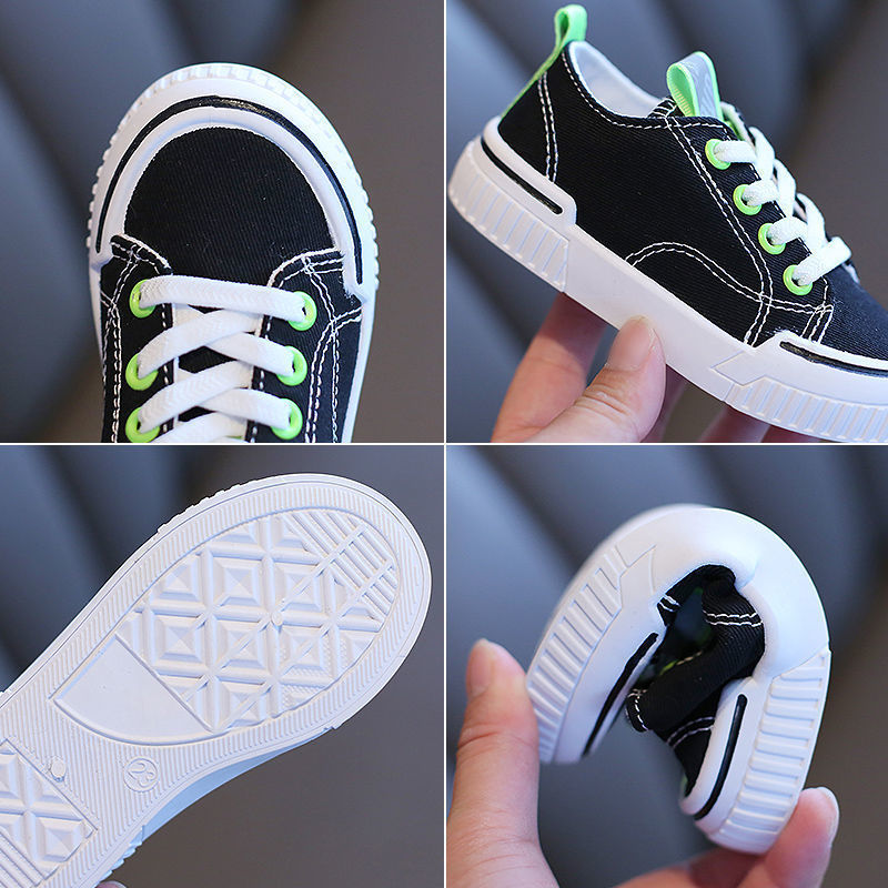 Black kids canvas sneakers with green laces, white rubber sole and textured tread