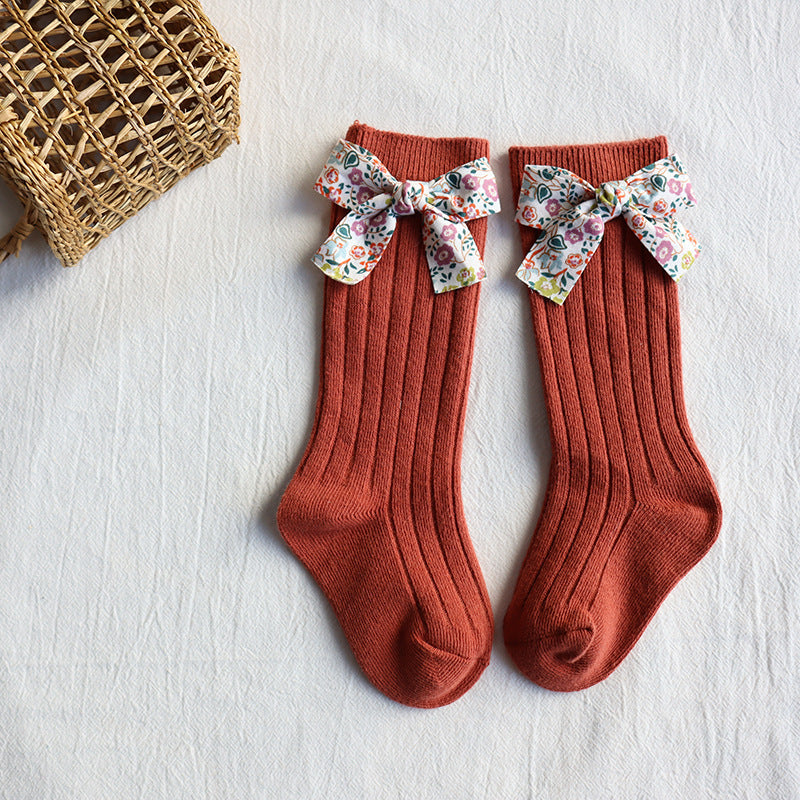 Baby long tube socks, terracotta red ribbed knit with multicolor floral bow cuffs