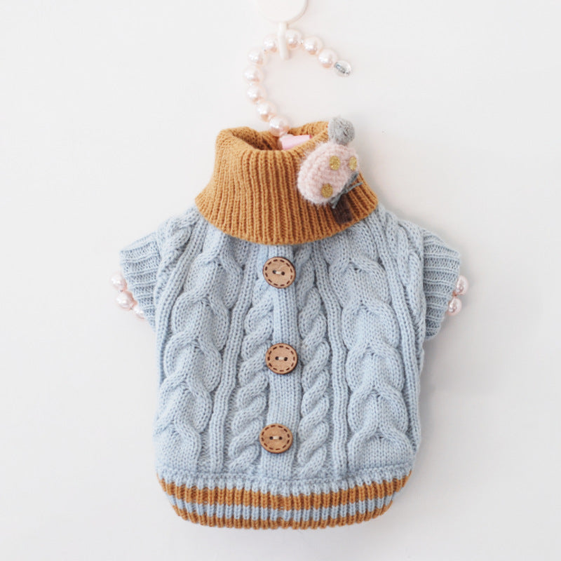 Blue cable-knit pet sweater with orange ribbed collar, striped hem, brown button accents