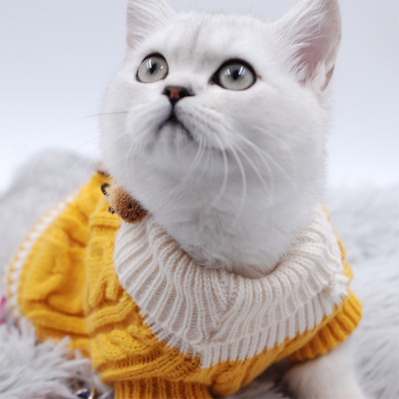 Knitted pet sweater on cat: white turtleneck, yellow cable-knit body, striped hem