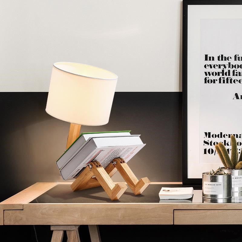 Wooden bedside desk lamp with white fabric shade on angled support