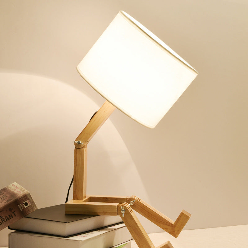 Wooden table lamp with white fabric shade and vertical wooden support arm