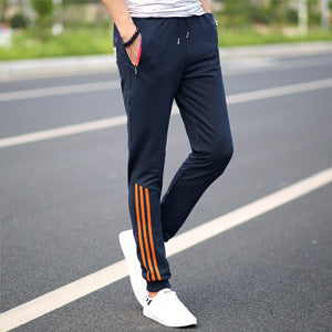 Men's dark blue slim casual pants with white side stripes and orange accent bands