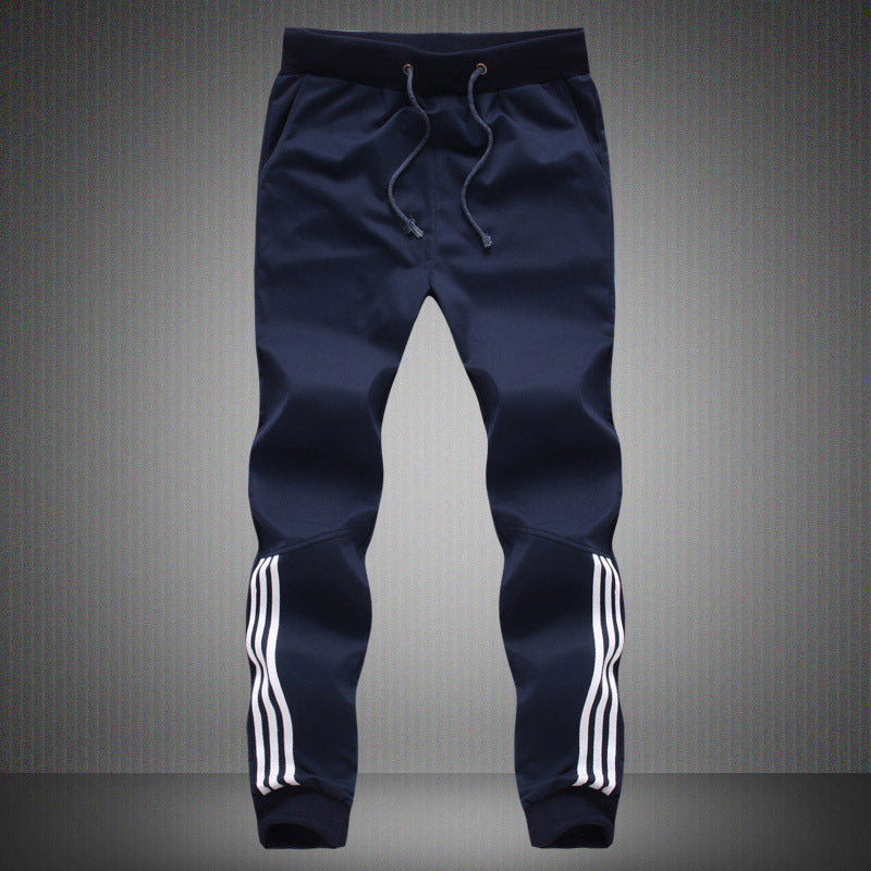 Men's navy jogger-style pants with drawstring and white triple stripe cuffs