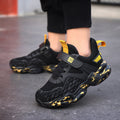 Children's black mesh sports shoes with yellow accents, hook-and-loop strap and cushioned sole