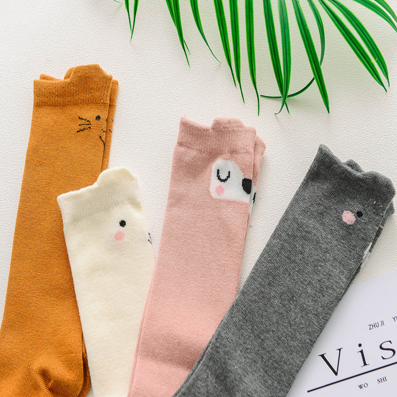 Children’s cartoon animal socks in orange, cream, pink, and dark gray with faces