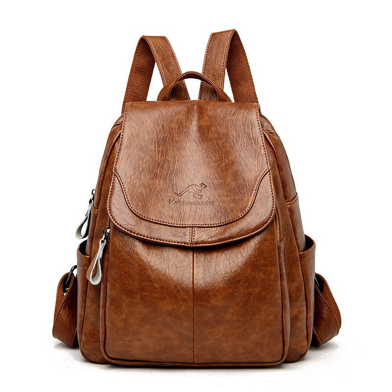 Women’s camel brown backpack with front flap pocket, top handle, and side zipper details